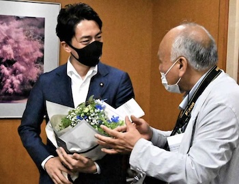 小泉進次郎が環境相退任時、花束を渡すベテランの記者の写真